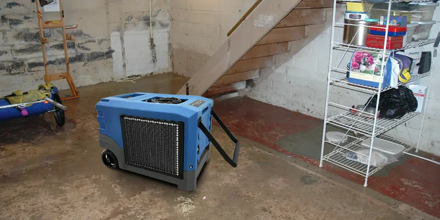 Dehumidifier drying a wet basement floor beside the stairs in Fresh Meadows
